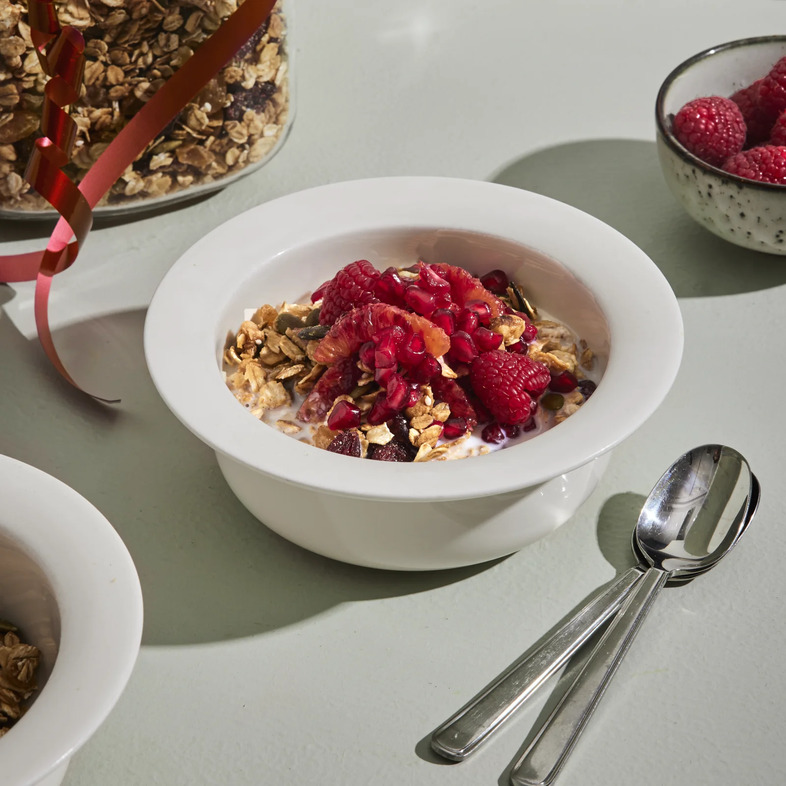 Hemgjord halva granola med havregryn, valnötter, pumpafrön och torkad frukt serverad i glasburk.