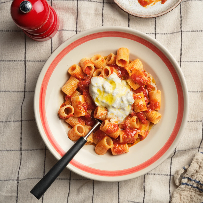 Snabb och smakrik tomatpasta med hetta från harissa, djup från paprikapuré och krämig burrata på toppen. Perfekt både vardag och helg.