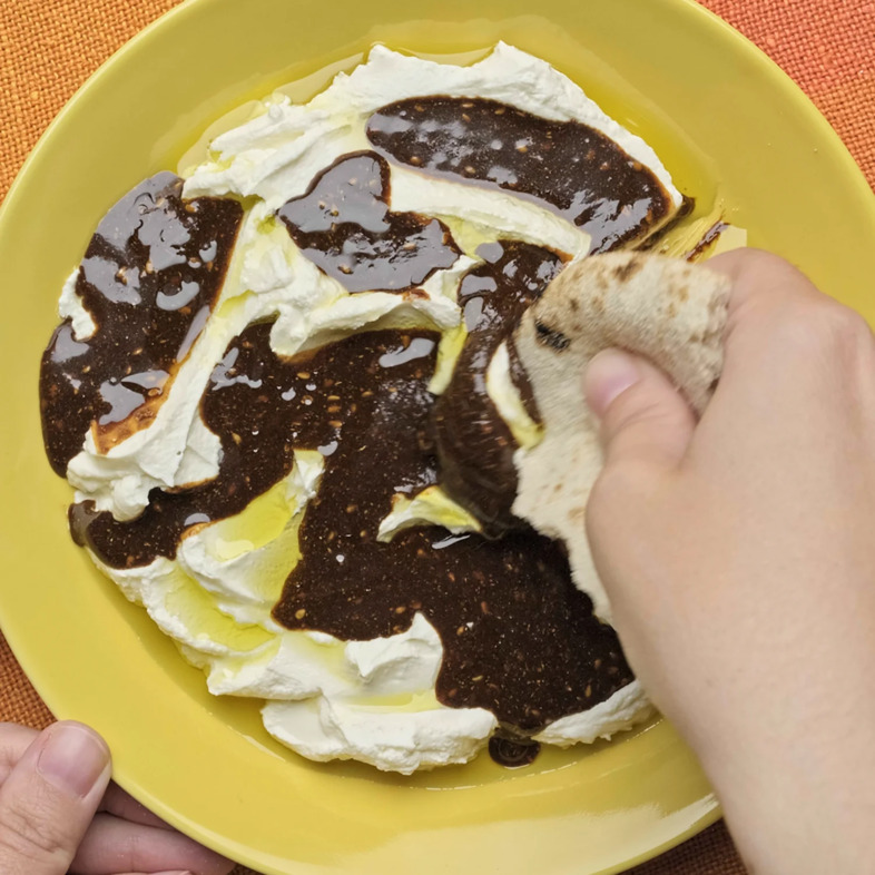 Krämig labneh toppad med za’atarsirap av Sevan Za’atar Aleppo, dadelsirap och olivolja, serverad med bröd