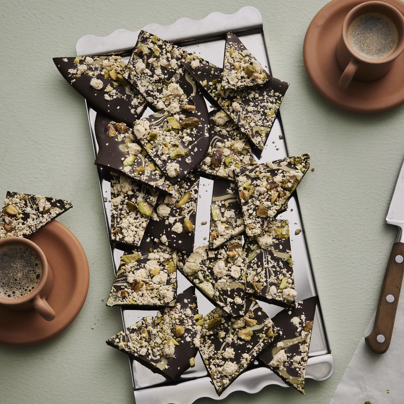 Chokladbark med mörk choklad toppad med pistagekräm, smulad halva och hackade pistagenötter.